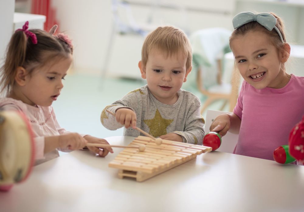 3 Children Playing A Game At The Table