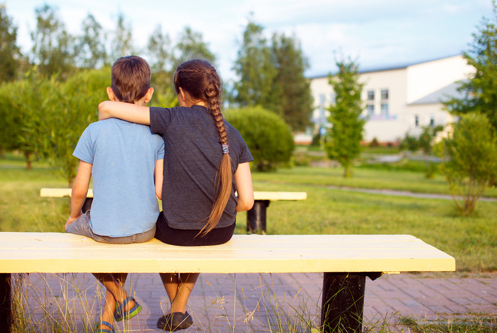 Boy and girl sat on bench