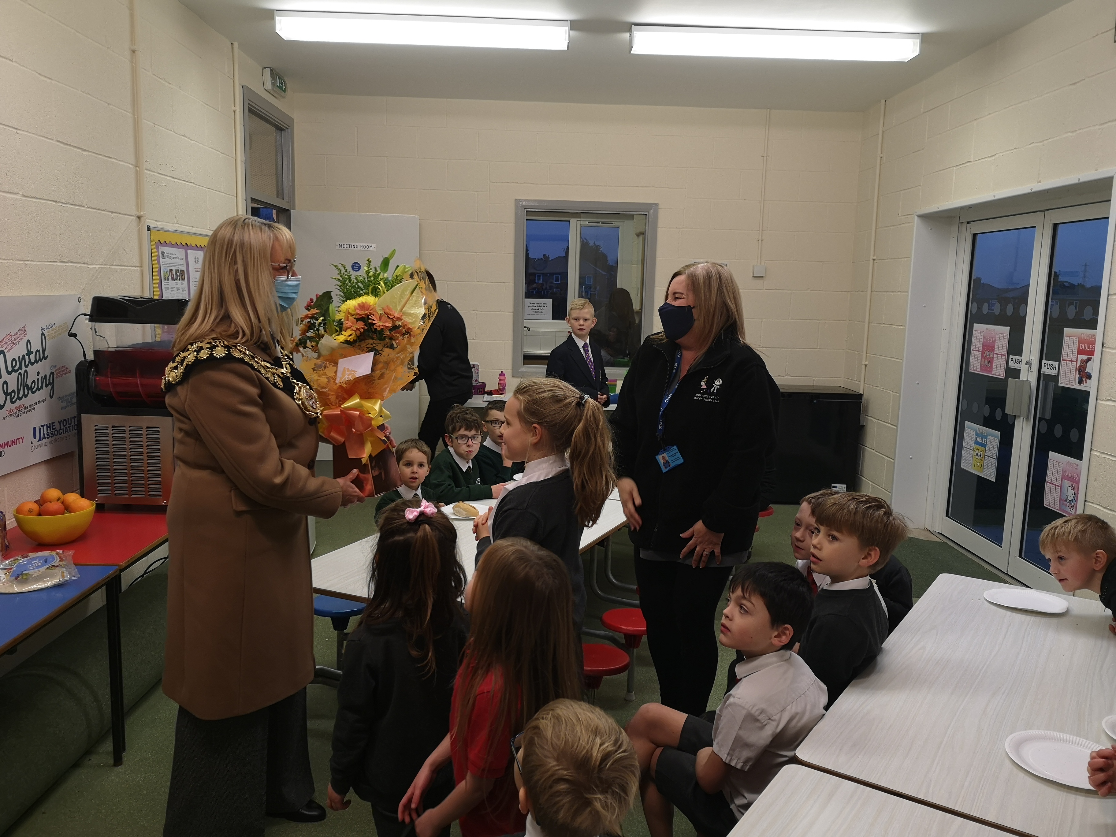 Photo of the Mayor being presented with a bunch of flowers at the Cool Kidz club