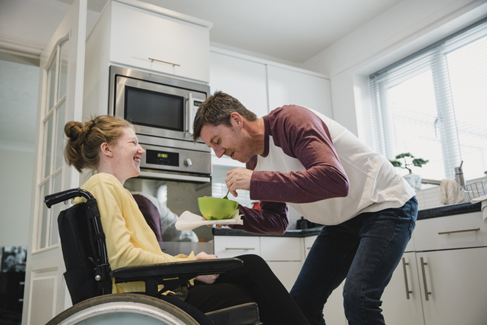 Father and disabled daughter in kitchen at home