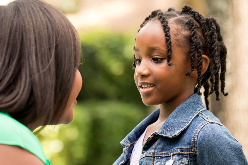 Young girl talking to adult