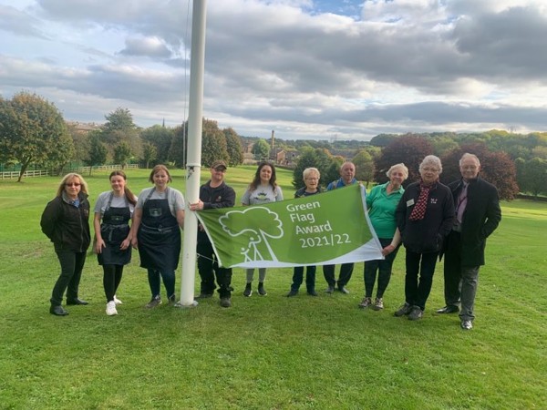 People in Elsecar Park with the Green Flag Award banner
