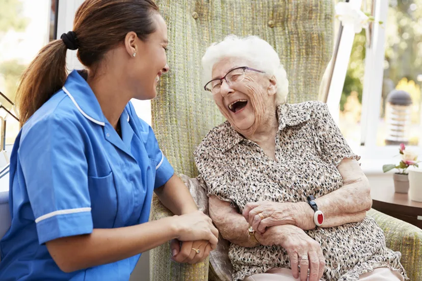 Senior woman laughing with carer