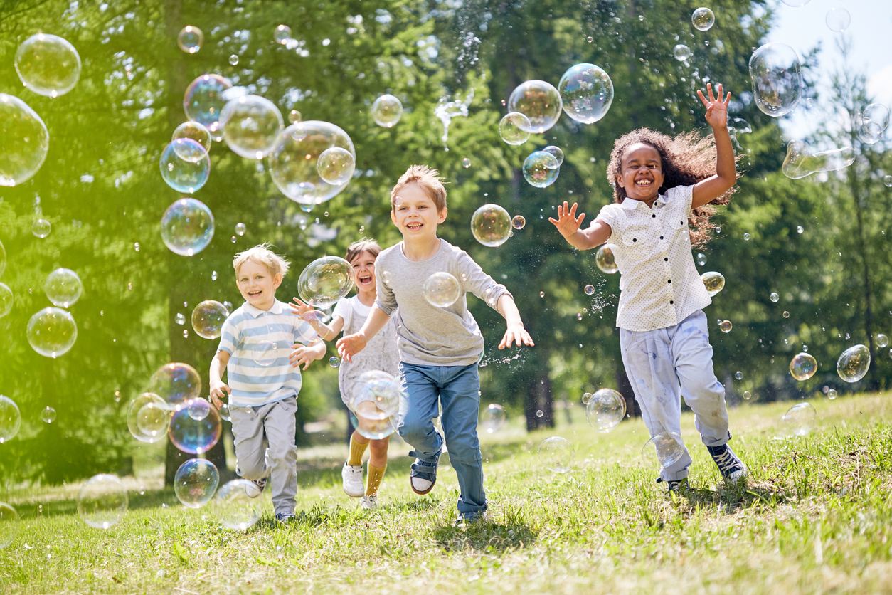 Children playing in park with bubbles