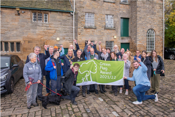 People at Worsbrough Mill holding Green Flag Award banner