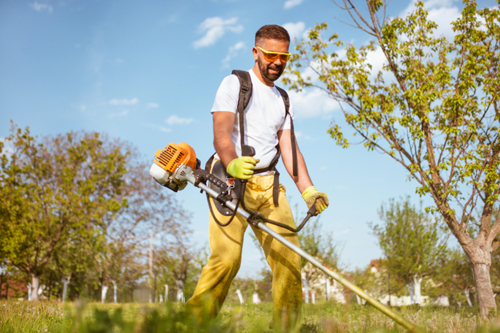 Man using grass strimmer