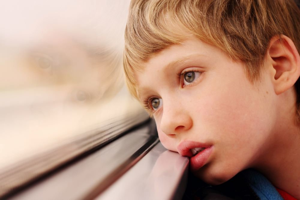 Boy looking out of a bus window