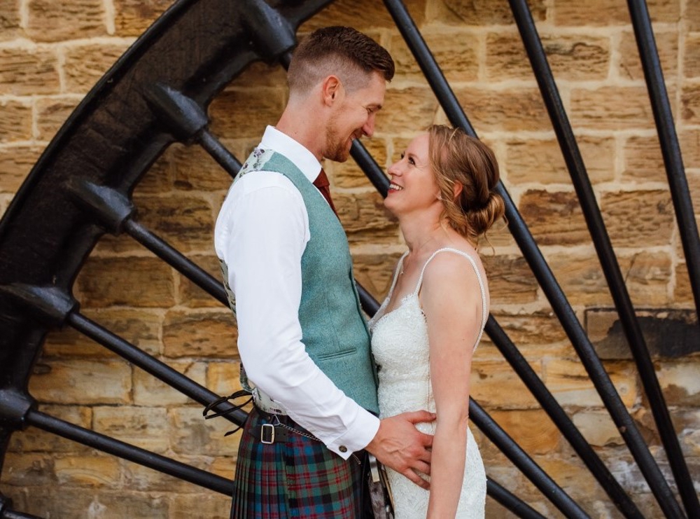 Bride and groom with wheel in background