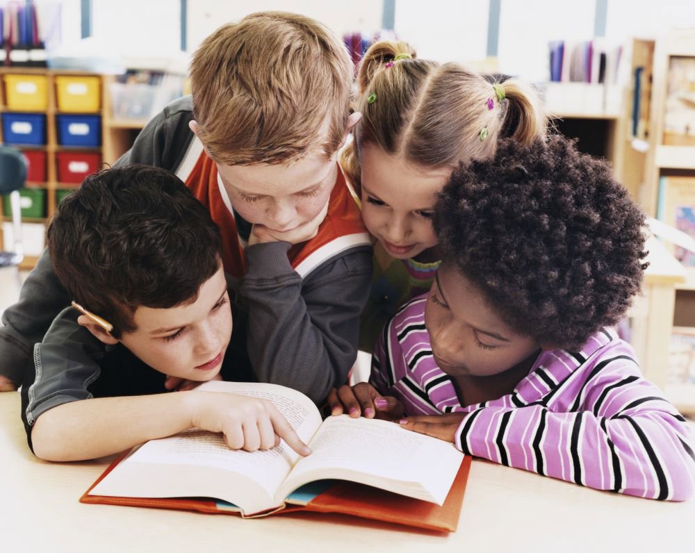 Group of young children looking at a book