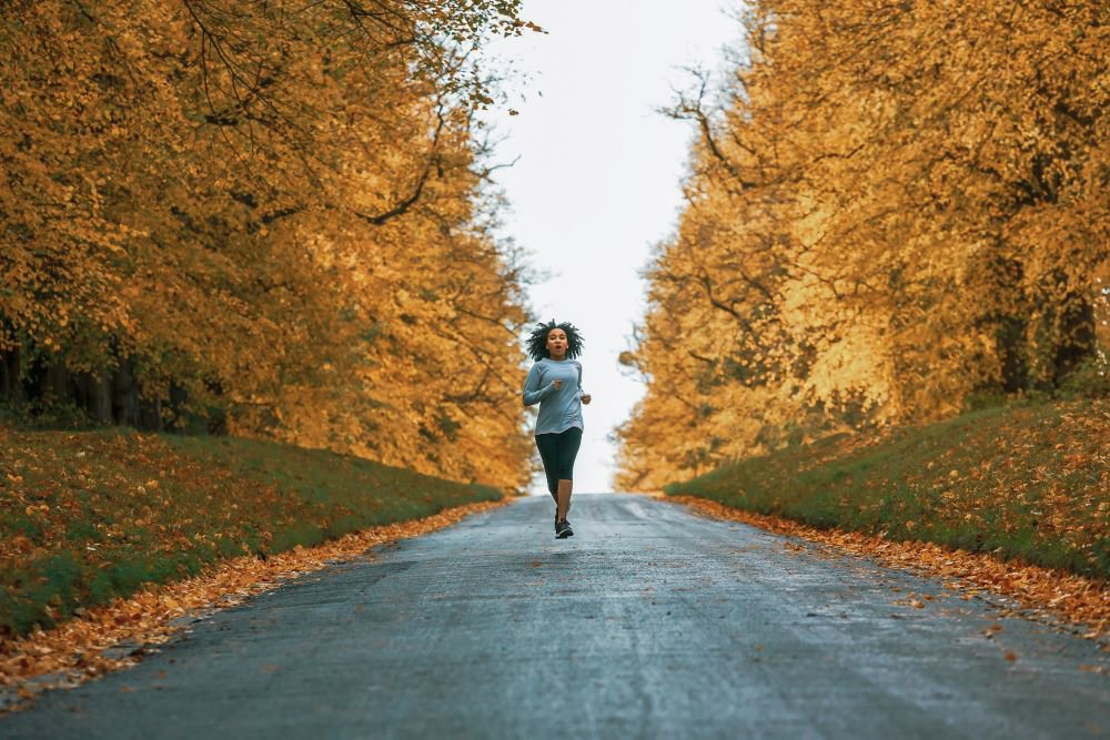 Woman running through a park in autumn