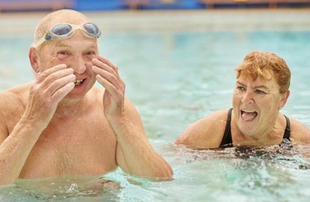 Couple laughing together in swimming pool