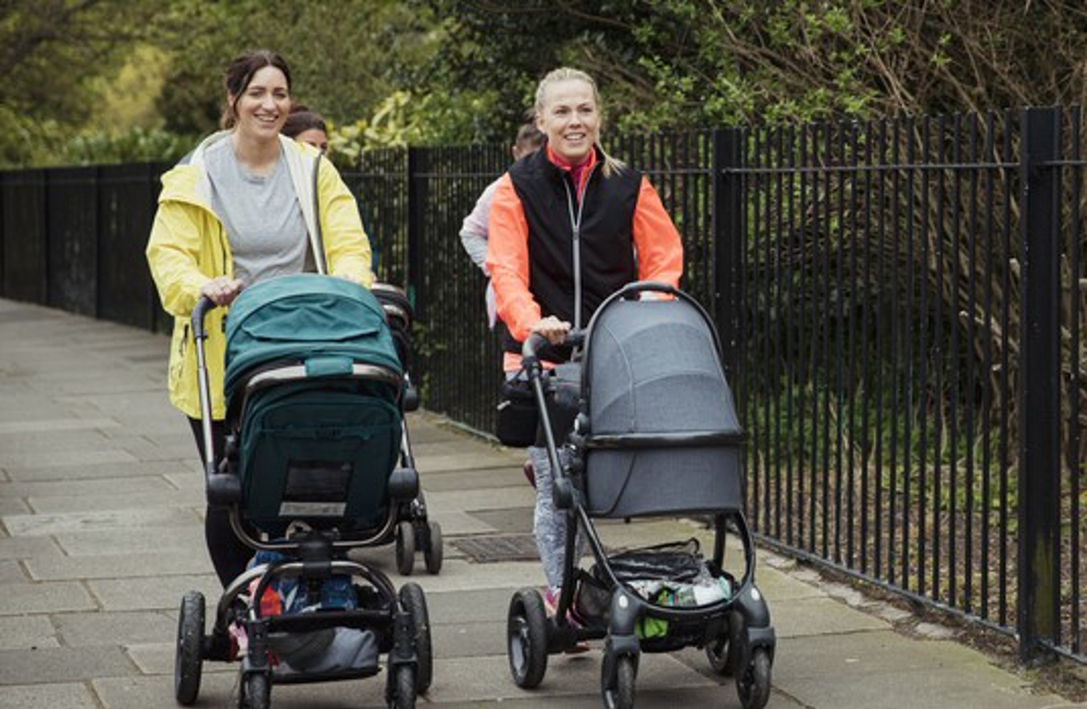 Two women walking with prams