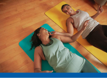 Two women laid on a yoga mat