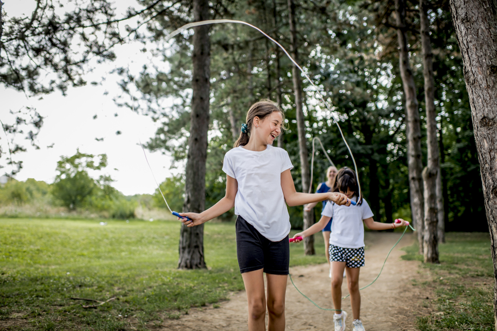 2 girls skipping through the park