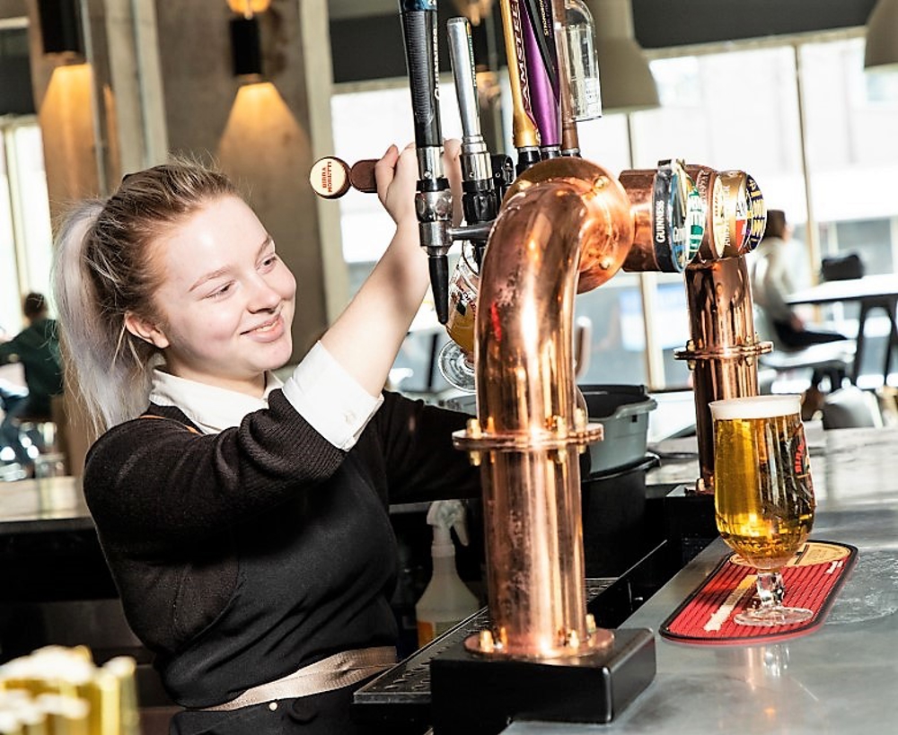 Bar server pouring beer