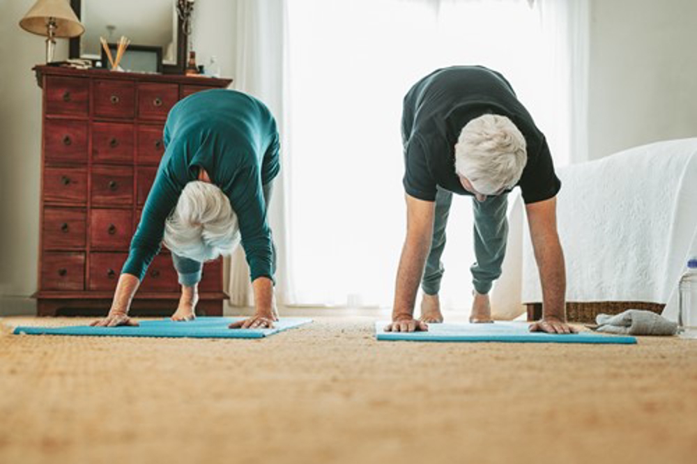 Older couple doing yoga at home