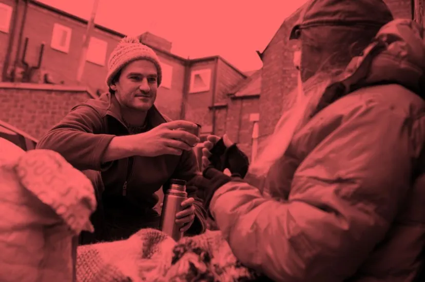 Person giving a flask to a homeless person