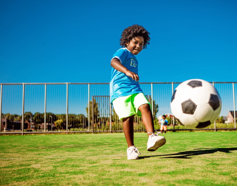 Child kicking football