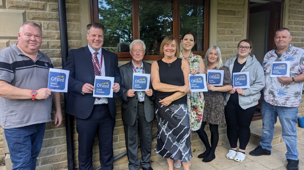 Photograph Of Staff Holding 'Good' Ofsted Rating Posters.