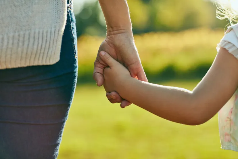 Adult and child holding hands