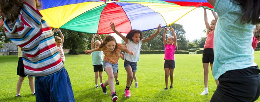 Children playing in the park under a big sheet