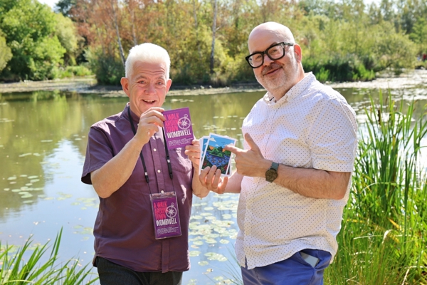 Two men beside a pond holding packs from the A Walk Around Town trail