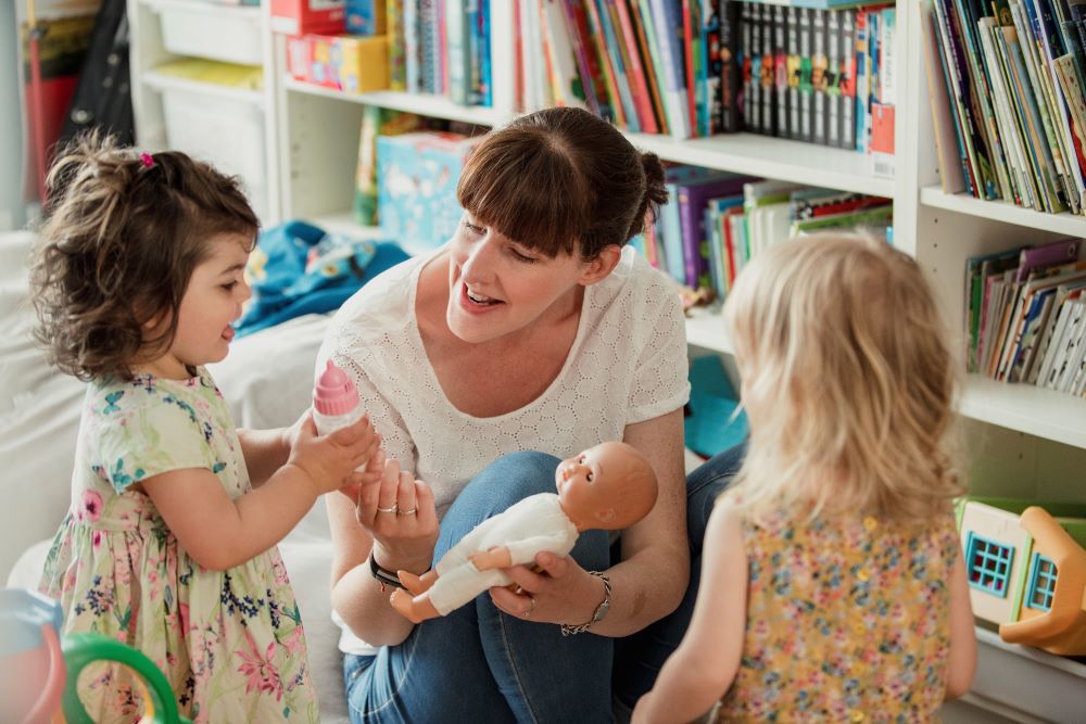 Childminder With 2 Children And A Baby Doll