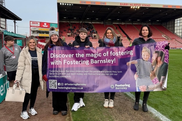 Fostering Barnsley Team Holding A Banner At Oakwell Stadium