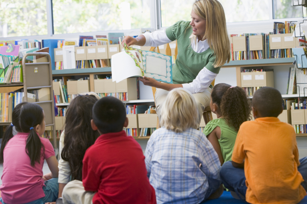 Teacher in class reading to children