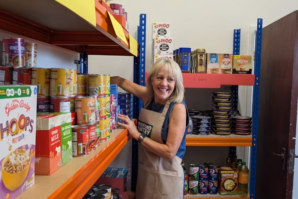 Photograph of woman by shelves of Gawber Good Food Pantry.jpg