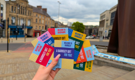 A hand holding Barnsley gift cards in the town centre.png