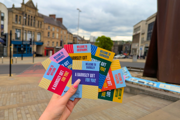 A hand holding Barnsley gift cards in the town centre.png