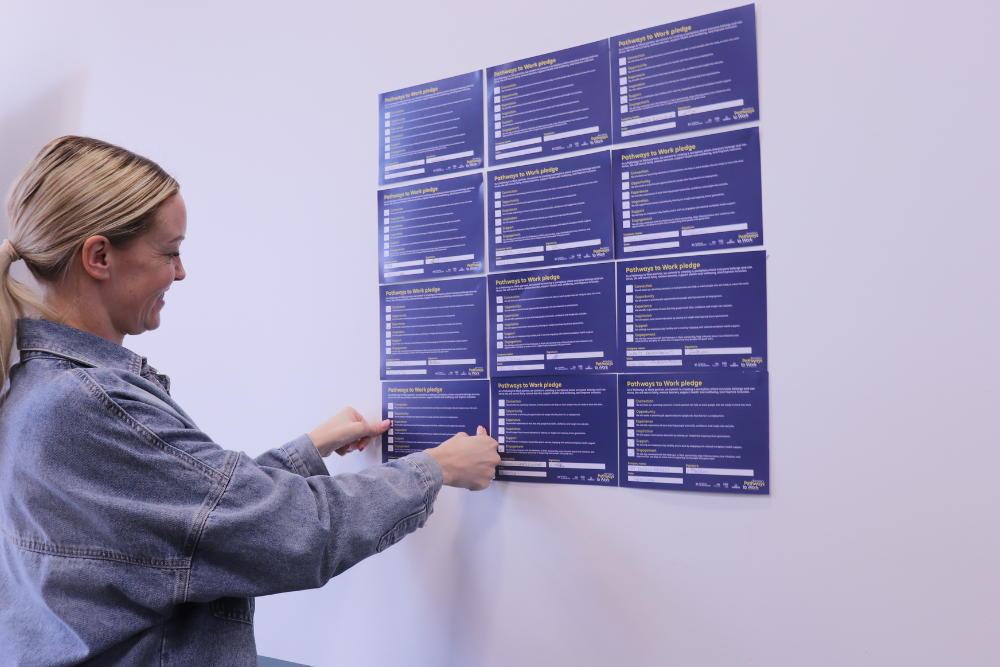 An employer putting her Pathways to Work partner pledge on the wall