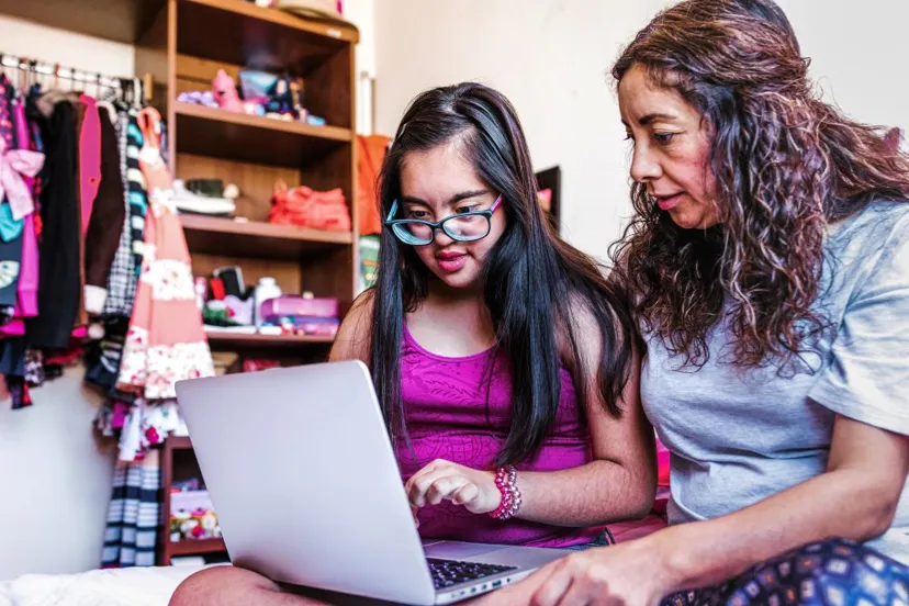 Girl Sat With Foster Carer On Laptop
